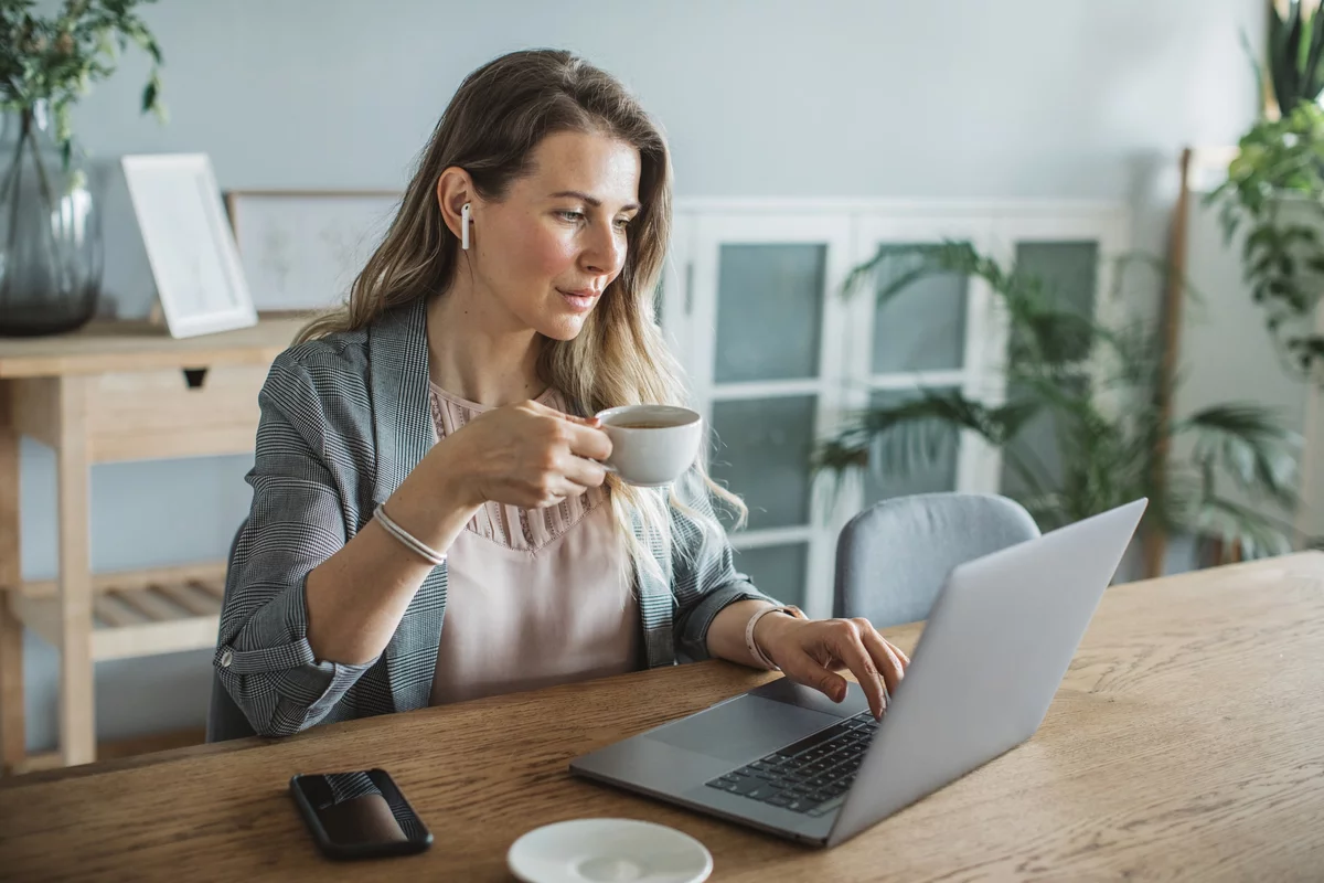 Devops inženýr s kávou v ruce pracuje na notebooku