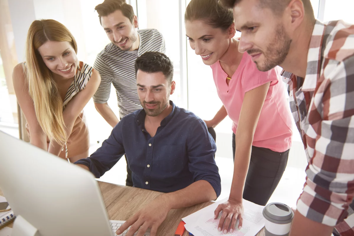 Skupina programátorů se dívá společně do monitoru počítače